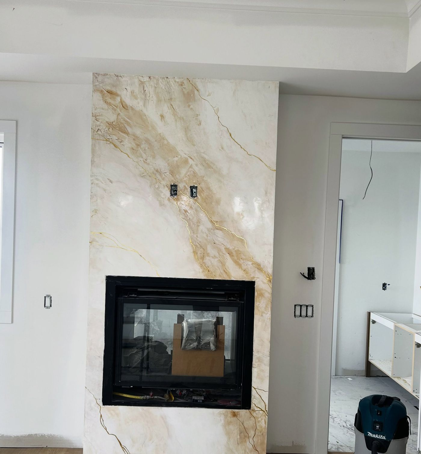 Cream and gold marble-finish fireplace in a new-build living room