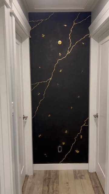 Black hallway wall with hand-painted gold veining and gold leaf detail