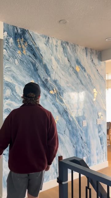 Floor-to-ceiling blue marble feature wall with gold leaf detailing