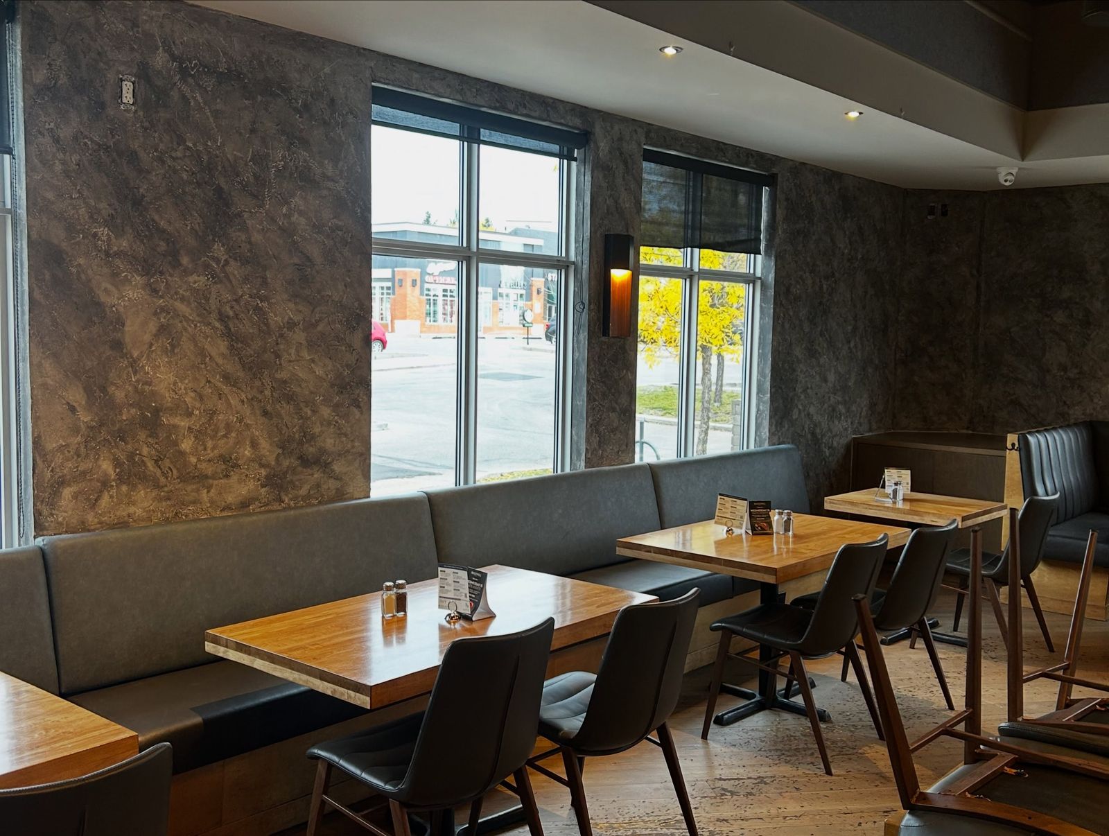 Restaurant booth seating against richly textured dark Venetian plaster walls